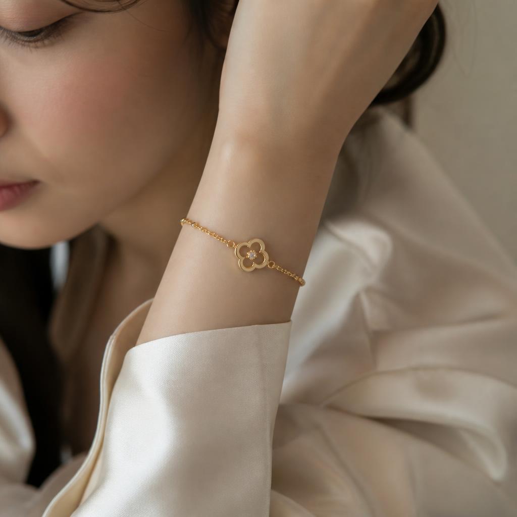 Close-up of a delicate gold bracelet on an East Asian woman's wrist with ivory silk cuffs
